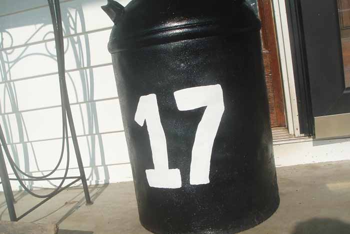 black painted milk can with white number on it