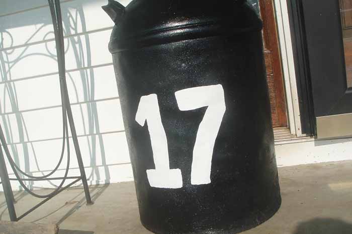 black painted milk can with white number on it 