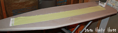 fabric rolled out onto ironing board