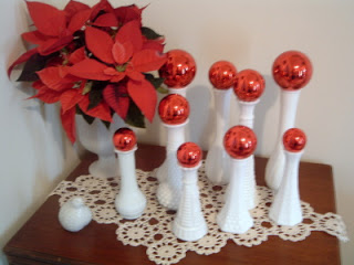 poinsettia with white vases topped with red ornaments