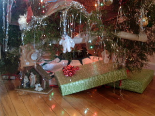 presents under a Christmas tree on a wooden floor 