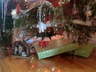 presents under a Christmas tree on a wooden floor