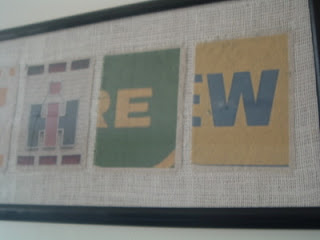close up of framed letter art on wall