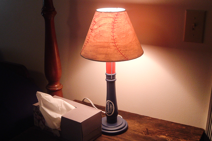 lamp lit up on a night stand.