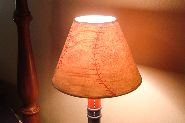 Baseball lamp shade with the light on.