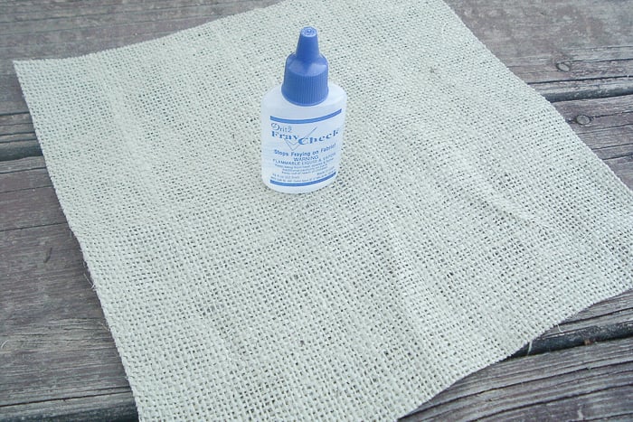 Using fray check on a burlap sheet, preparing to make our burlap throw pillow