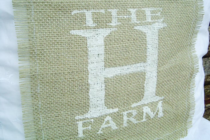 Farm monogram on a burlap pillow attached with a simple stitch along the edges of the burlap