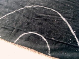 outline of a pirate hat drawn on black fabric