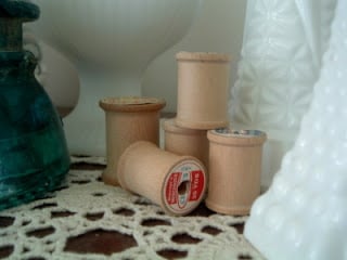 vintage wooden thread spools on a doily