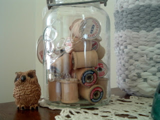 mason jar filled with wooden thread spools