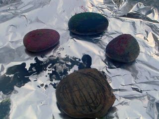 crayon painted rocks on aluminum foil