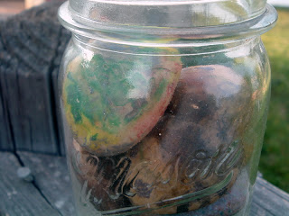 crayon painted rocks in a lidded glass mason jar