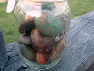 mason jar with wax painted rocks on a deck