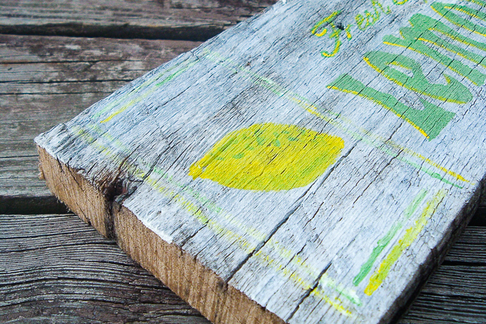 Lemon painted end of rustic wood painted sign.