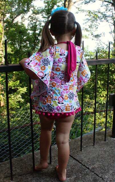back of little girl wearing floral beach cover up