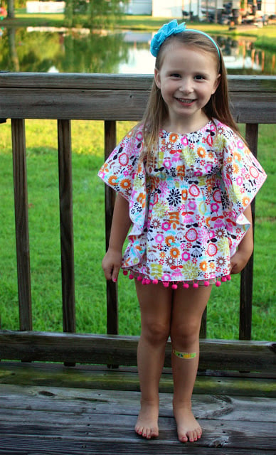 little girl with floral cover up on deck