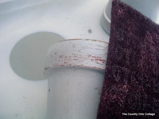 using a scotch brite pad to remove paint from a pot