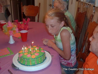 girl blowing out candles on birthday cake