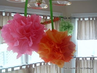 pink and orange tissue paper balls hanging from chandelier