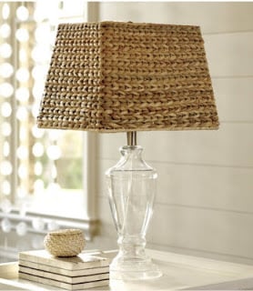 Ballard Designs seagrass lamp shade on a white table next to stacked books