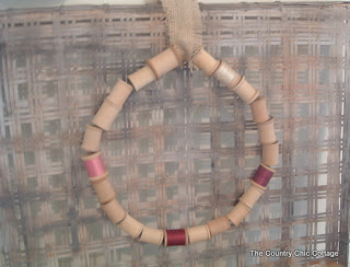 hanging a wooden spool wreath on a tobacco basket with burlap ribbon