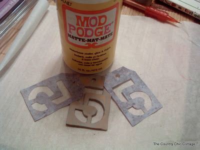 Use Mod Podge and a paintbrush to add rusted metal paper to the clay tag.
