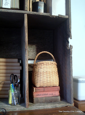 basket and vintage books in a wooden hutch