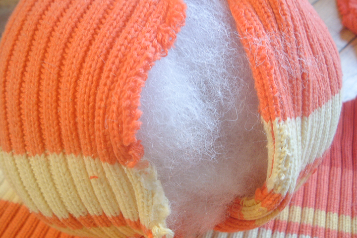 adding fiber fill stuffing to a sweater pumpkin