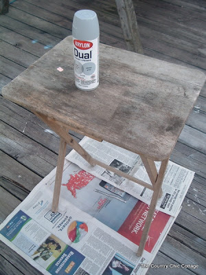 old folding table on top of newspaper with spray paint can