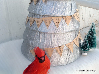 red bird in front of stacked silver tree