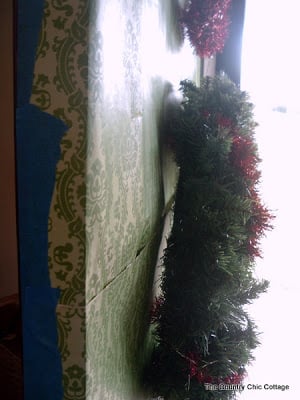 wrapping paper taped onto front door with side view of wreath