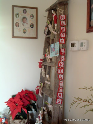 Antique ladder Christmas Display with glitter Christmas banner hanging on side.