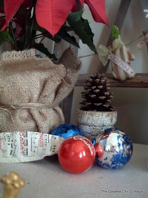 Christmas ornaments on a table in front of burlap 