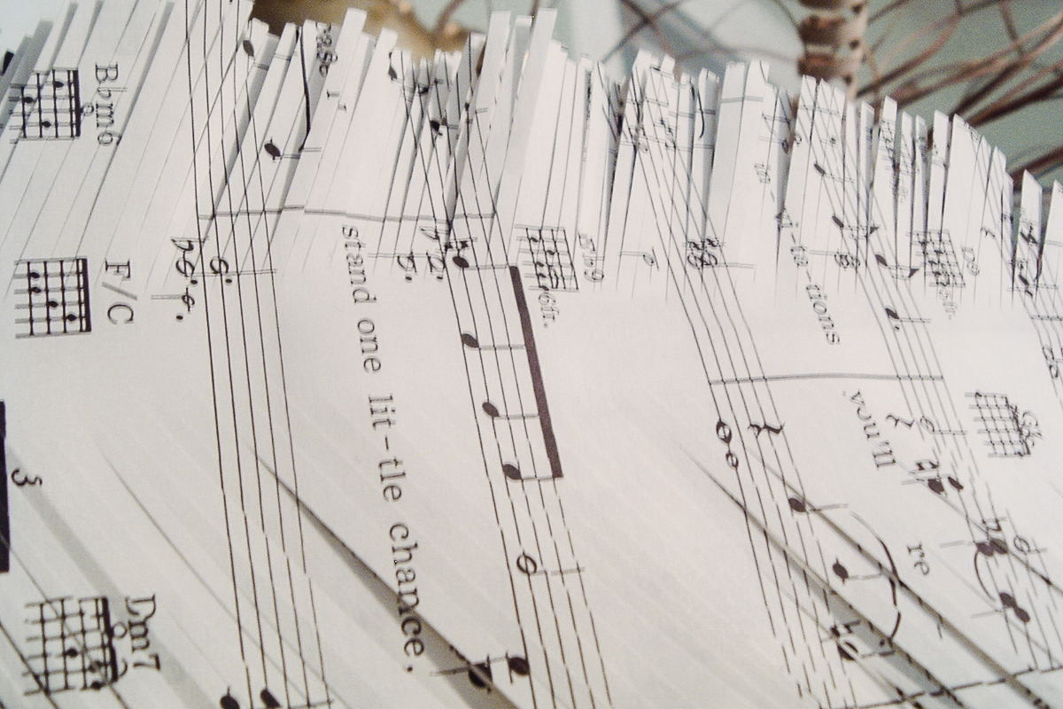 white sheet music made into a paper feather