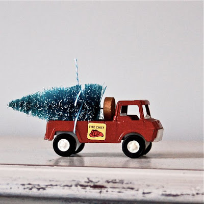 vintage toy truck carrying a Christmas tree