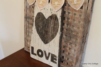 Wooden sign painted white with heart and word "love"