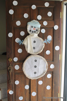snowman on a wood door with snowballs