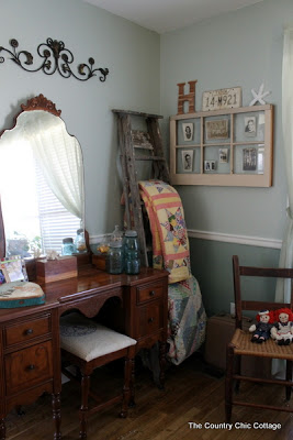 Corner of a room with quilt ladder, window and dressing table