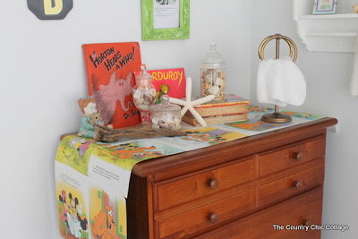 Chest of drawers in the bathroom with book decor.