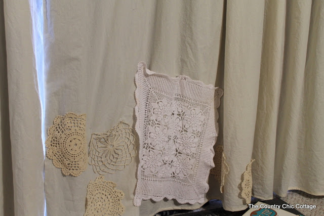 trying to pin doilies on curtains