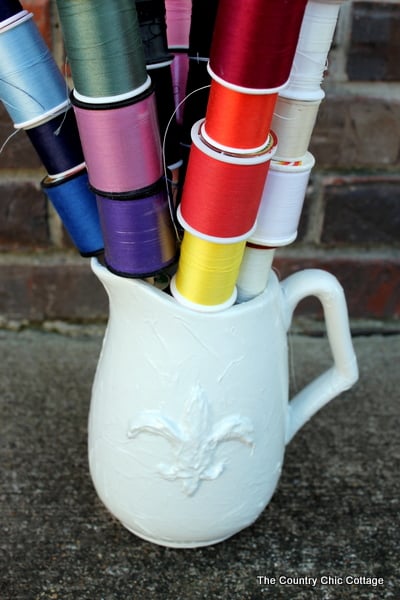 spools of thread stacked in pitcher