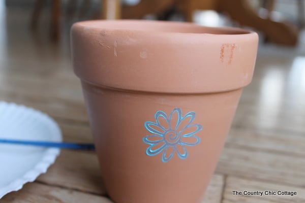 blue flower stamped on a terra cotta planter