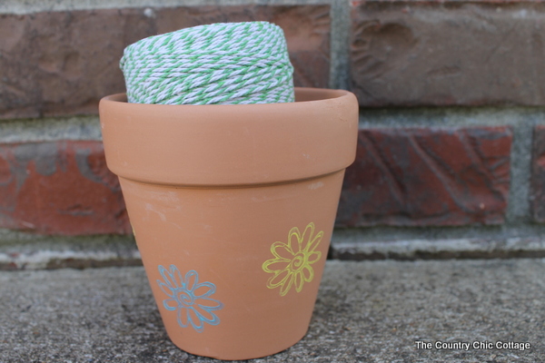 blue and yellow flower stamped on a planter with twine inside