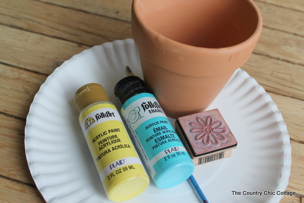 blue and yellow folkart paint with a planter and paper plate