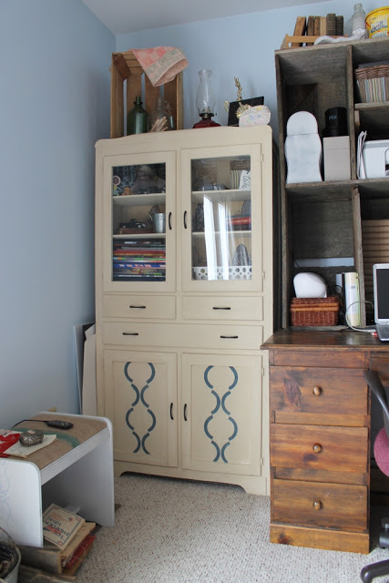 cream antique painted cabinet with wooden crate on top