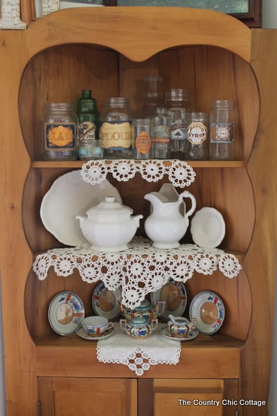 DIY Vintage Labels corner shelf with a variety of bottles that have diy vintage labels
