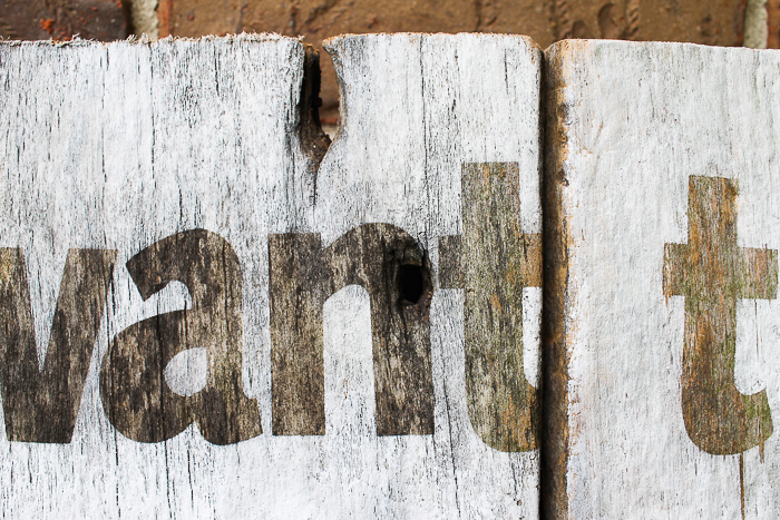Holes in barn wood that has been made into a home decor sign