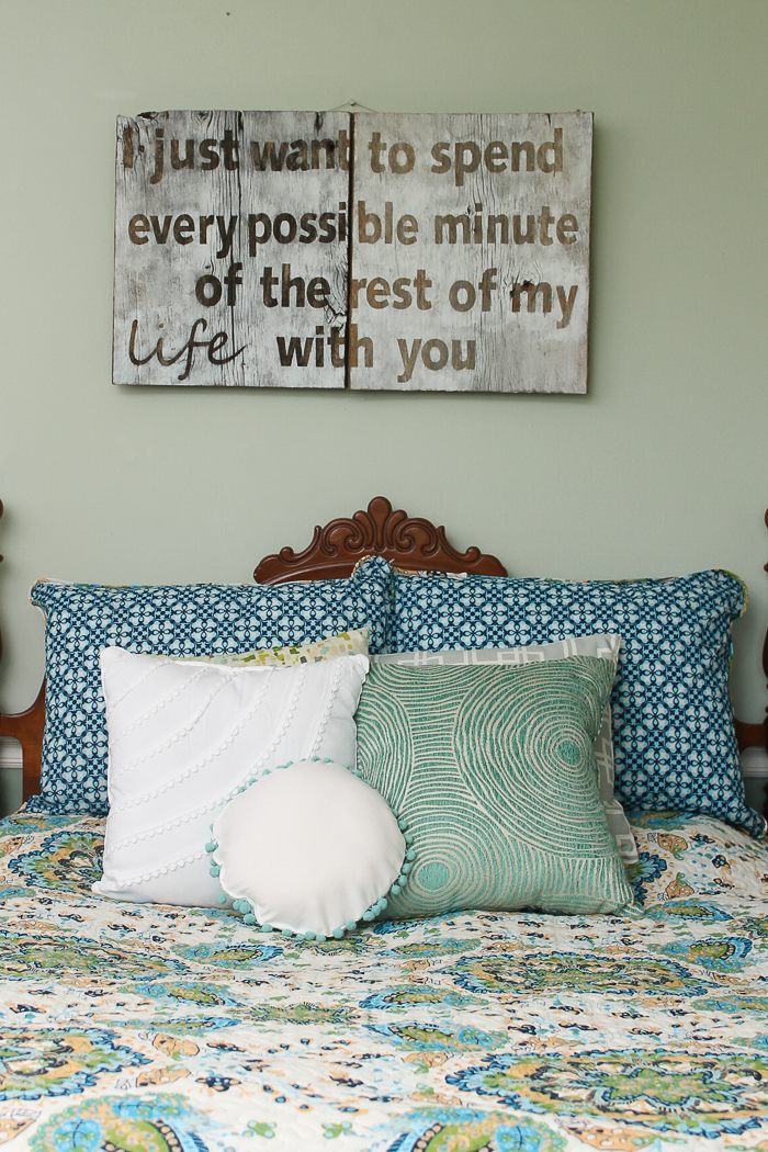 DIY wooden sign with saying above a bed
