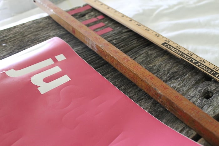 using rulers to line up vinyl on a sign