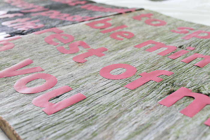 red vinyl letters on a barn wood sign